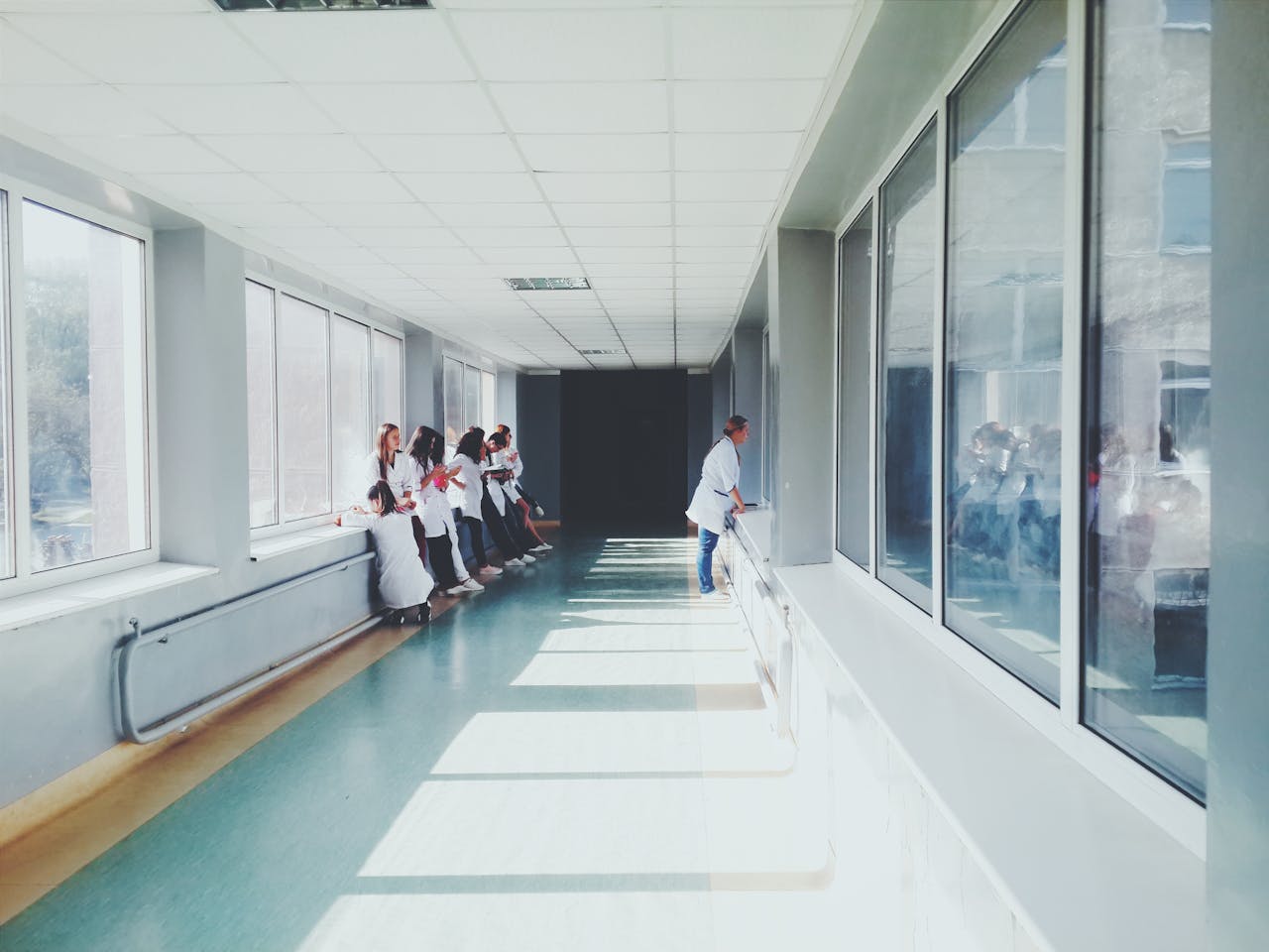 portfolio-08 A brightly lit hospital hallway with medical staff in white coats, conveying a professional healthcare environment.